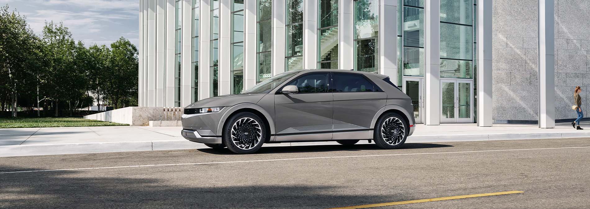 A silver Hyundai parked outside a glass building.