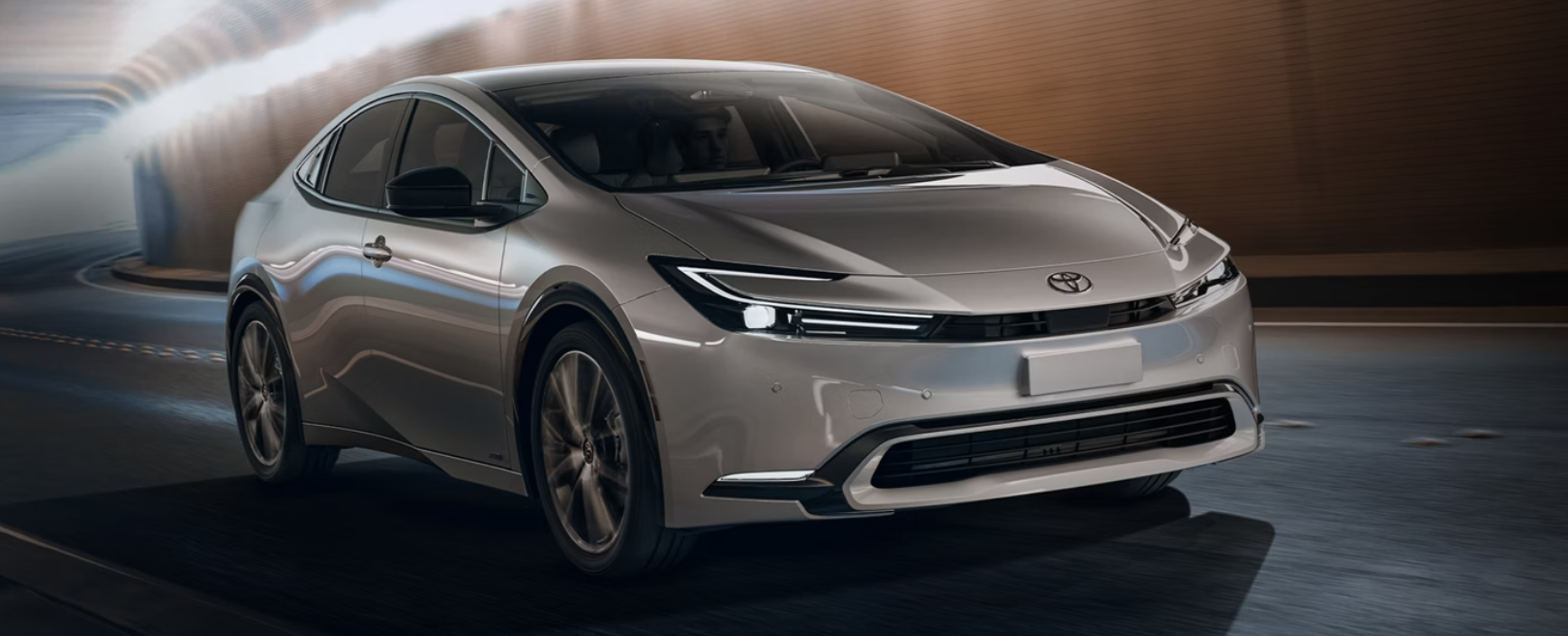 A grey Toyota Prius driving down a tunnel.